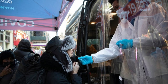 A woman gets tested in a mobile COVID-19 testing van