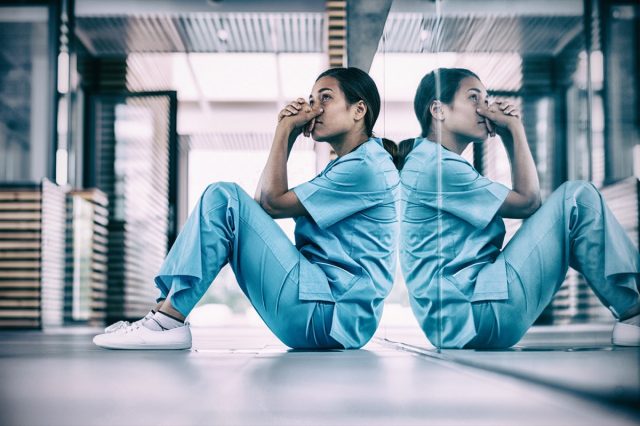 Worried nurse sitting in hospital hallway
