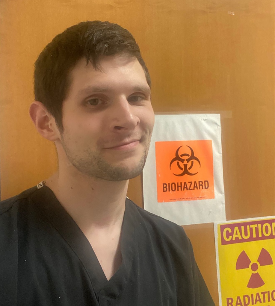 Jake Eberts stands in front of the biohazard sign
